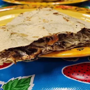 Side view of half a Tlayuda folded over. Sometime served open face like a pizza!