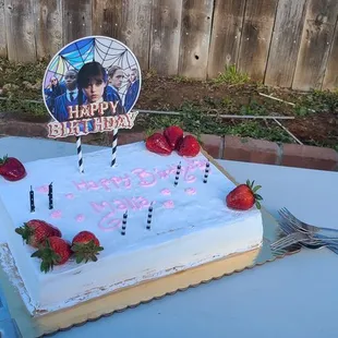 a birthday cake with candles and strawberries