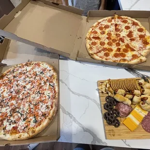 two pizzas in boxes on a table