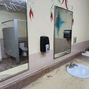 a man taking a picture of a bathroom