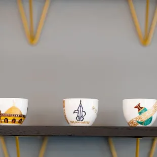 three cups on a shelf