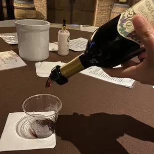 a person pouring a glass of wine