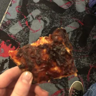 a person holding a slice of pizza