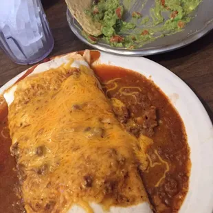 a plate of enchiladas and a bowl of guacamole