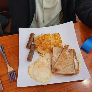 Basic breakfast with 2 eggs, sausage  hash brown&apos;s, and wheat toast.