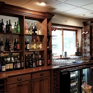 a bar with wine bottles on the shelves