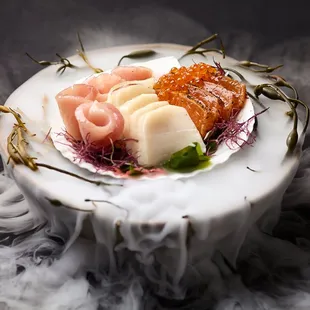 Scented water poured over dry ice beneath fresh sashimi.