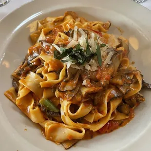 a plate of pasta with mushrooms and parmesan cheese