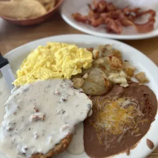 Country Fried Steak with Eggs, Beans, Potatoes and a side order of Bacon.