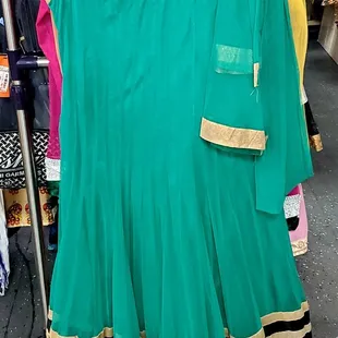 a green and gold dress hanging on a rack