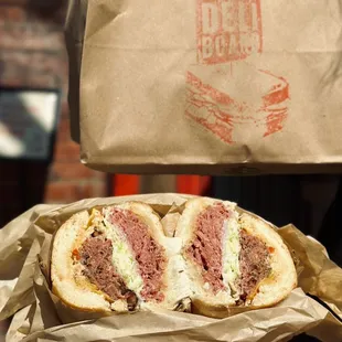 a person holding a sandwich in a paper bag