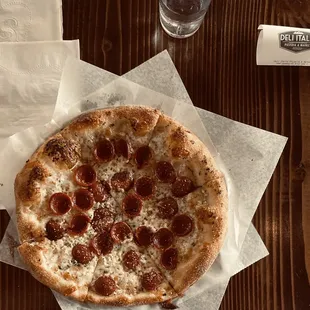 a pepperoni pizza on wax paper