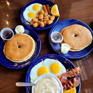 a breakfast of pancakes, eggs, hash browns, and bacon