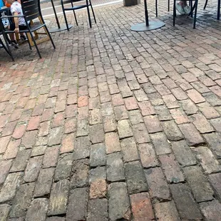 a brick patio with tables and chairs