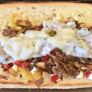 a beef sandwich with cheese and peppers