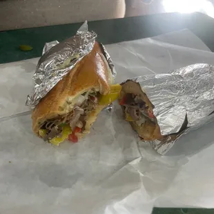 a half eaten sandwich on a piece of tin foil