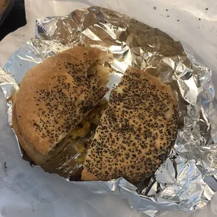 a half eaten sandwich on a foil wrapper