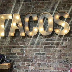 a taco&apos;s sign on a brick wall