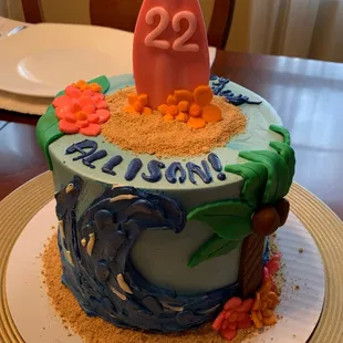 a birthday cake decorated with a surfboard