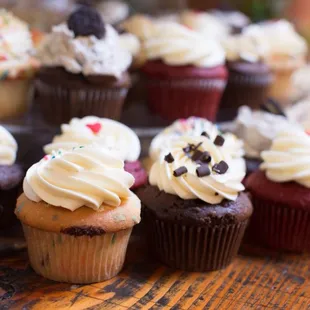 a variety of cupcakes on a wooden table