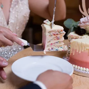 a bride and groom cutting their wedding cake