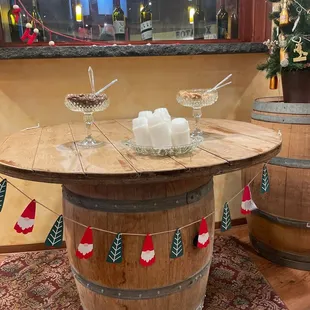 a wine barrel table with wine glasses and candles
