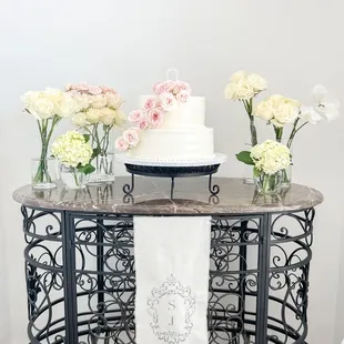 a table with a cake and flowers