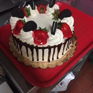 a cake decorated with strawberries and oreo cookies