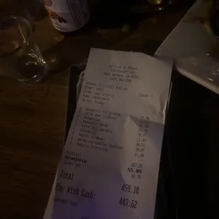a receipt and a glass of wine