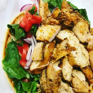 a salad with chicken, tomatoes, and lettuce