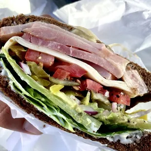 a person holding a sandwich in their hand