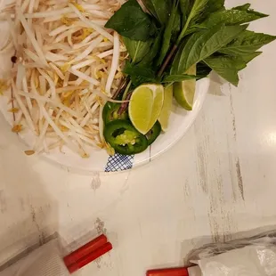 a plate of noodles and a lime wedge