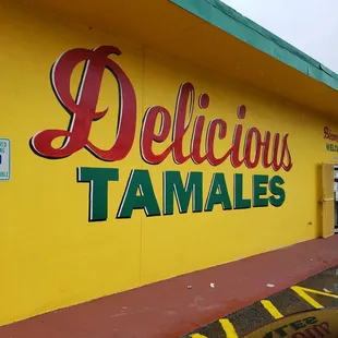 a yellow building with a sign that says delicious tamales