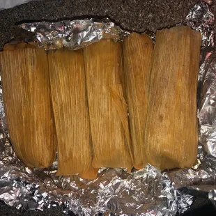 a close up of a tamales on tin foil