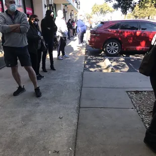 a line of people waiting outside a restaurant
