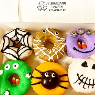 a variety of decorated donuts in a box