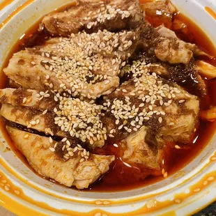 a bowl of stew with meat and sesame seeds