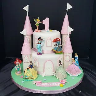 a princess castle cake with princess figurines