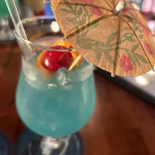 a blue drink with an umbrella