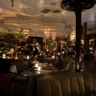 the interior of a restaurant with people sitting at tables