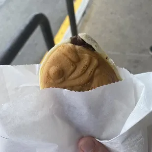 a person holding a sandwich in a wrapper