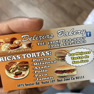 a hand holding two business cards