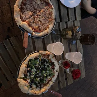 two pizzas on a wooden table