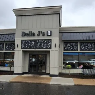 The outside building of Della J's. Plenty of parking and a nice looking establishment.