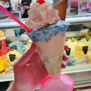 a hand holding a cone of ice cream