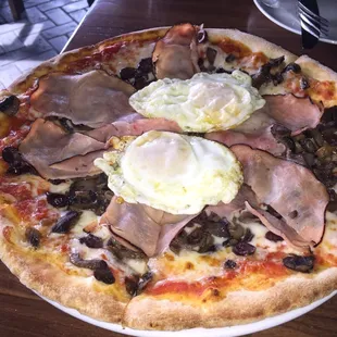 "La Regina" pizza with poached eggs, olives, and ham.  Great pizza to share for an early lunch.