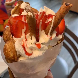 an ice cream sundae with strawberries and whipped cream