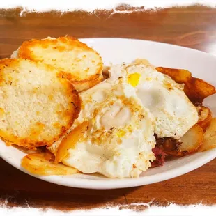 Corned Beef Hash (ordered extra crispy) with home fries, two eggs over easy, and a biscuit.