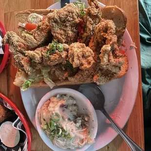 Fried chicken poboy with mashers, fried okra, and hush puppies.