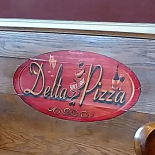 a wooden bench with the name delta pizza